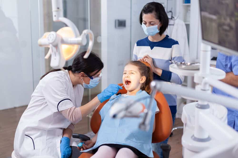 a little girl is getting dental treatment